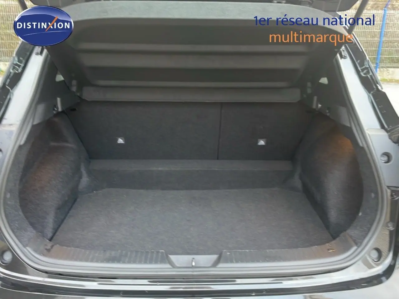 Coffre ouvert d'un Nissan Qashqai noir métal 2023, vue arrière montrant l'espace de chargement vide et propre.