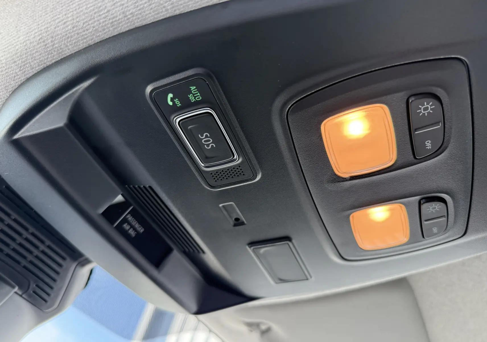 Détail intérieur du plafonnier avec boutons SOS et éclairage allumé dans un Renault Trafic cabine approfondie noir.