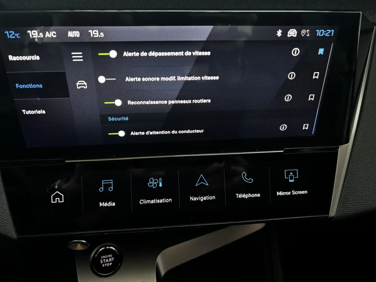Écran tactile central de la Peugeot 308 Hybrid 136 e-DCS6 Allure affichant les options de sécurité, intérieur noir.