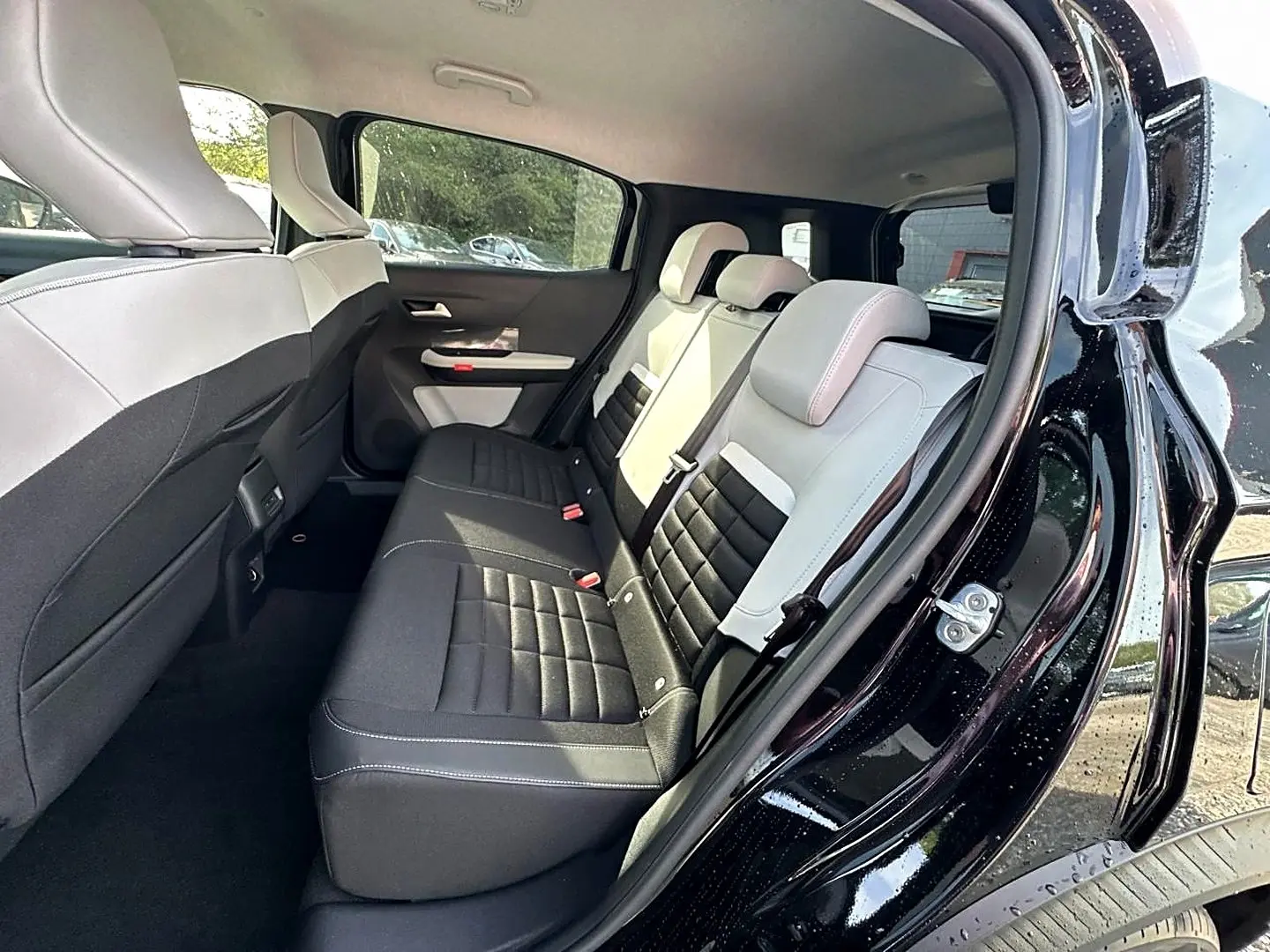 Vue intérieure côté droit sur la banquette arrière bicolore noire et beige du Citroën C3 Aircross noir 2026.