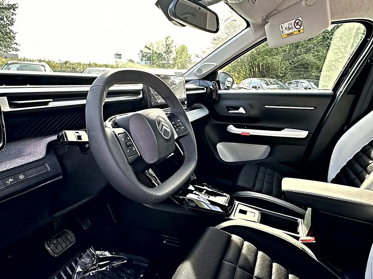 Vue intérieure côté conducteur du Citroën C3 Aircross 2026 noir, volant multifonction et sellerie noire avec accoudoir clair.