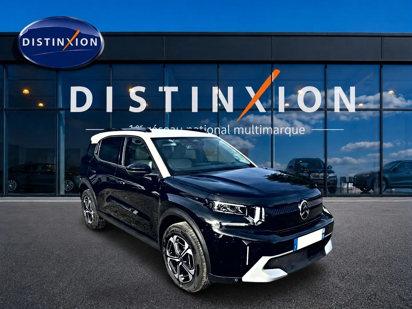 Citroën C3 Aircross noir avec toit blanc, vue 3/4 avant droite devant une vitrine Distinxion.
