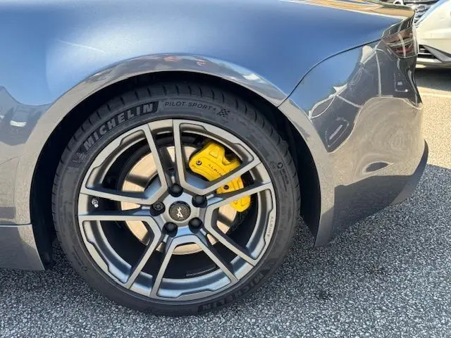 Gros plan sur la roue arrière droite d'une Alpine A110 gris acier avec étrier de frein Brembo jaune et jante alu 18'' Fuchs.