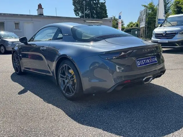 Vue 3/4 arrière droite de l'Alpine A110 1.8T 252 Légende gris acier, jantes 18'' Fuchs et étriers Brembo jaunes visibles.