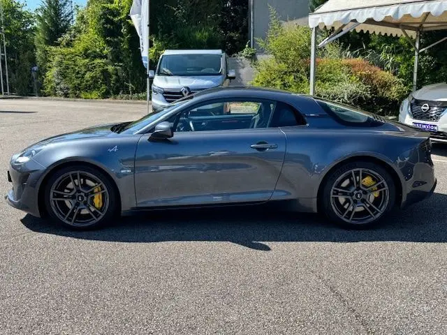 Profil côté gauche de l'Alpine A110 1.8T 252 Légende gris acier avec jantes 18'' FUCHS et étriers Brembo jaunes visibles.