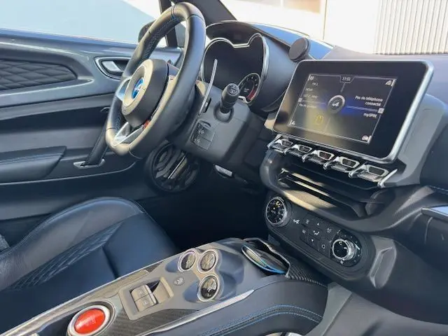 Intérieur de l'Alpine A110 1.8T 252 Légende 2021, vue côté conducteur, cuir noir surpiqué bleu et console carbone brillant.