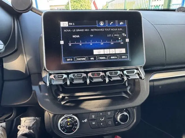 Tableau de bord de l'Alpine A110 1.8T 252 Légende 2021, écran tactile et commandes climatisation visibles en gros plan.