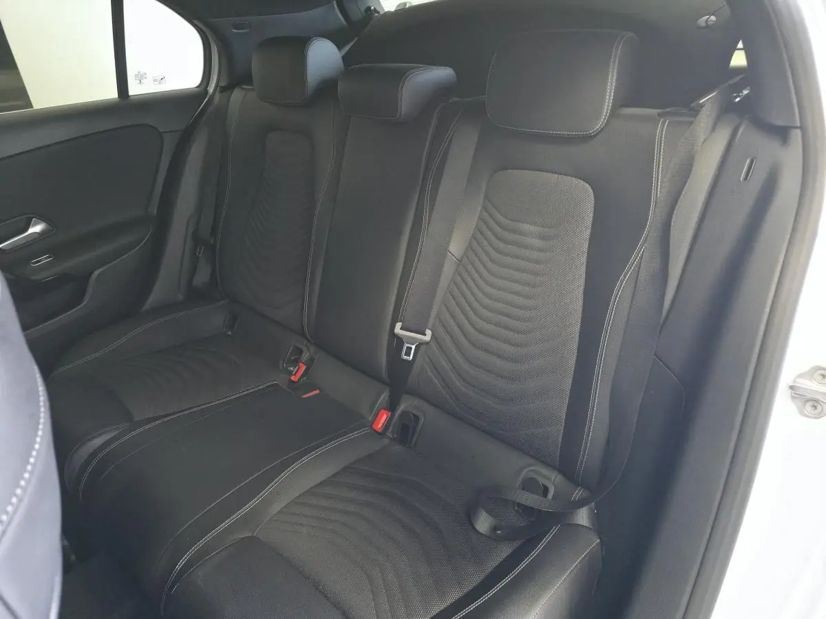 Vue intérieure côté droit des sièges arrière en tissu noir de la Mercedes Classe A 160 Style Line blanche de 2019.