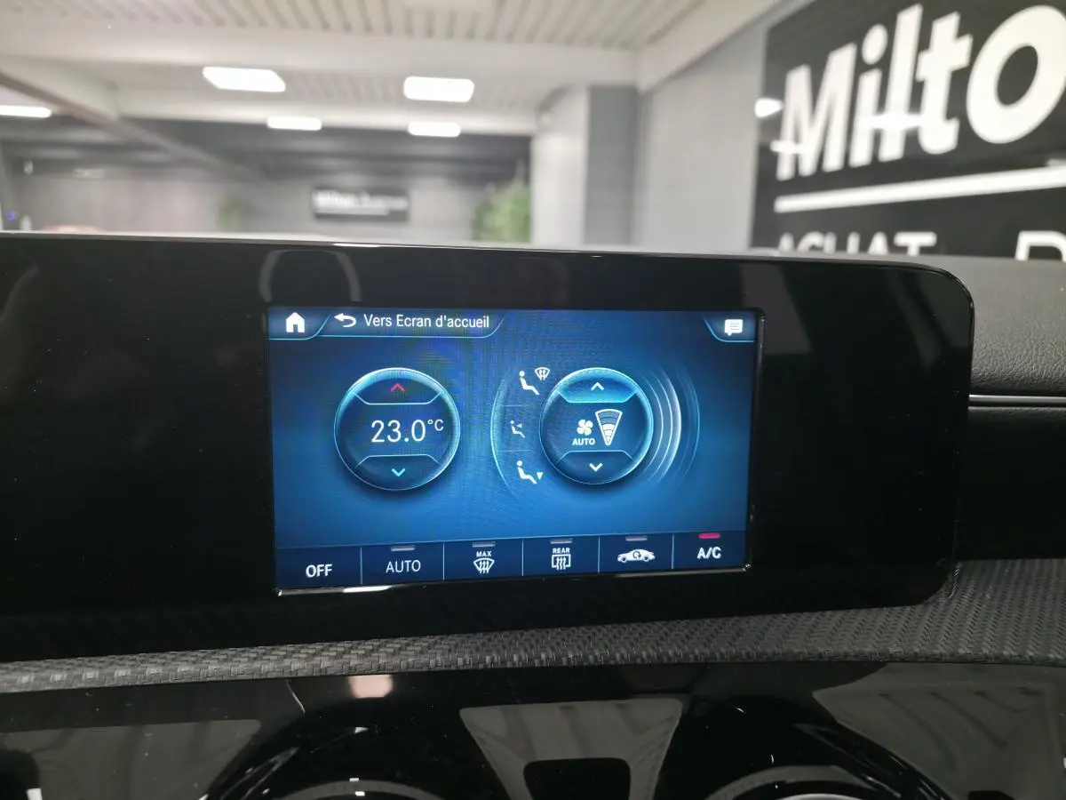 Écran tactile central de la climatisation affichant 23°C dans une Mercedes Classe A blanche de 2019.