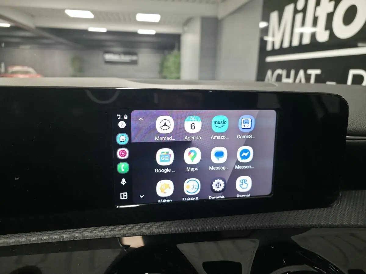 Écran tactile central MBUX affichant les applications smartphone dans l'habitacle de la Mercedes Classe A blanche.