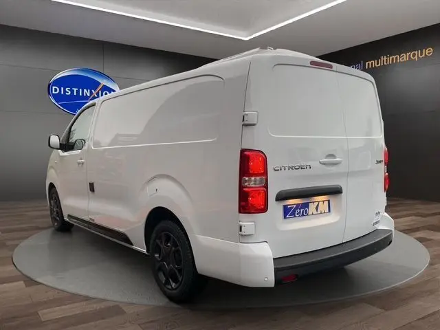 Vue 3/4 arrière droite d’un Citroën Jumpy XL blanc, utilitaire avec portes arrière pleines et jantes noires.