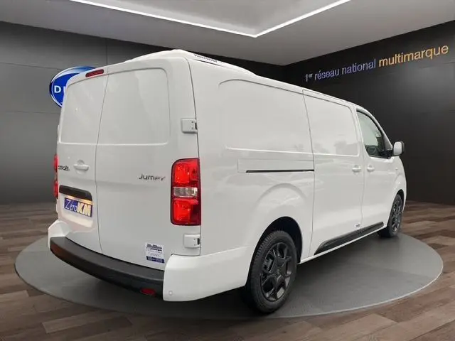 Vue 3/4 arrière droite d’un Citroën Jumpy XL blanc, utilitaire avec portes arrière pleines et jantes noires.