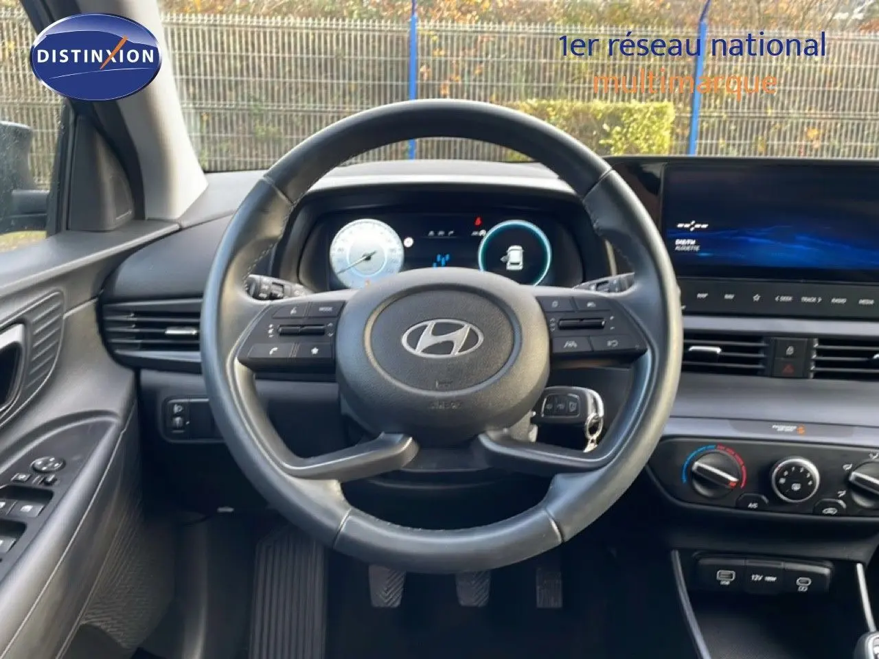 Vue intérieure centrée sur le volant de la Hyundai i20 2025, avec tableau de bord numérique et écran tactile.