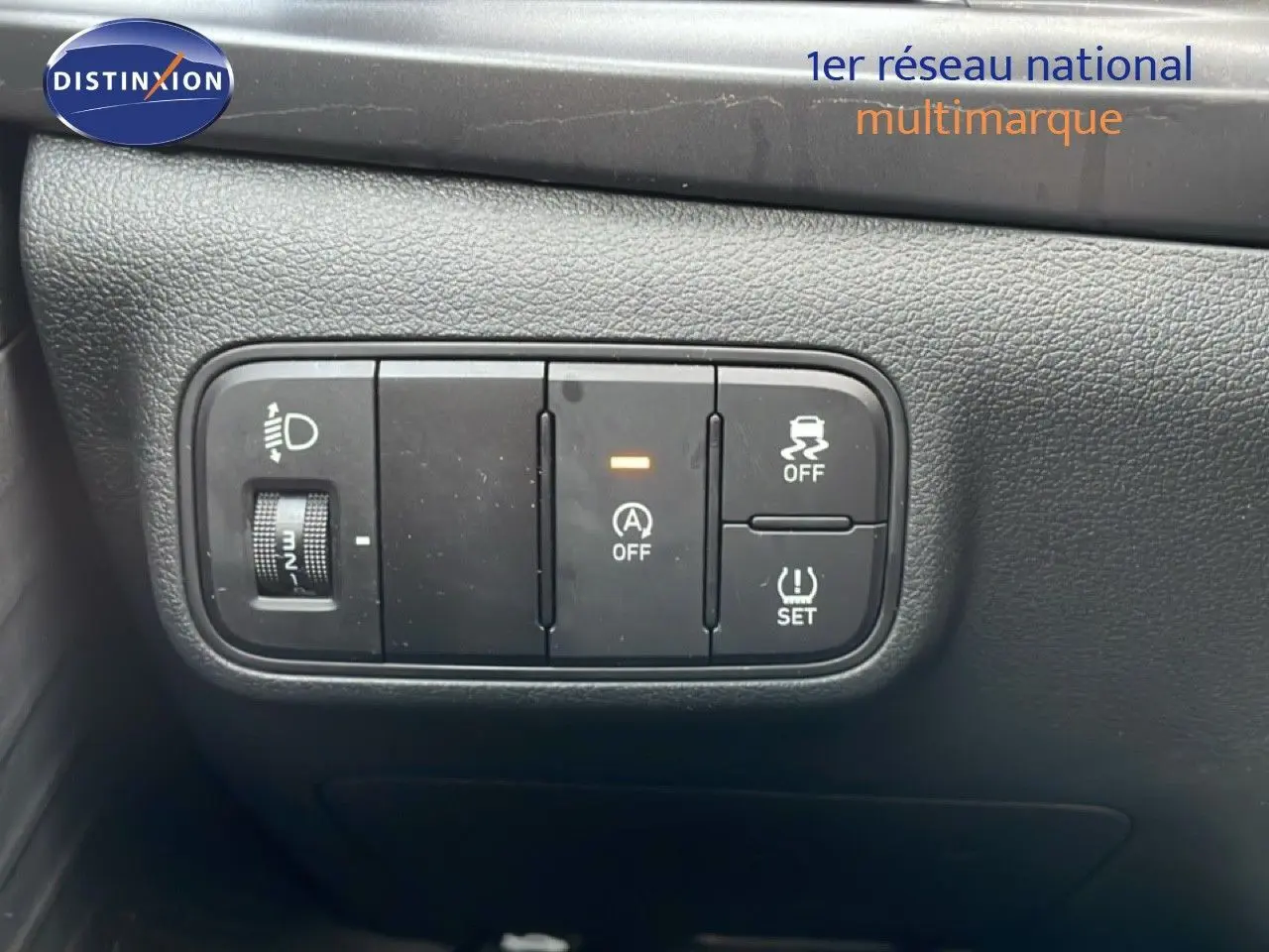 Gros plan sur les commandes de réglage des phares et d'assistance à la conduite dans l'habitacle d'une Hyundai i20 bleu vibrant metal.