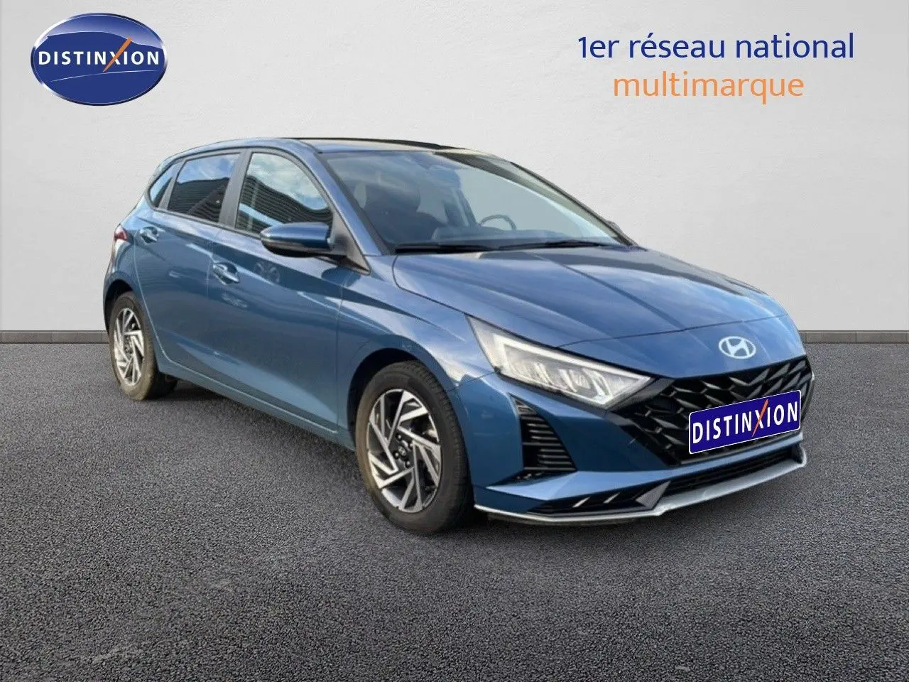 Hyundai i20 2025 bleu vibrant métal vue 3/4 avant droit avec calandre noire et phares LED distinctifs.