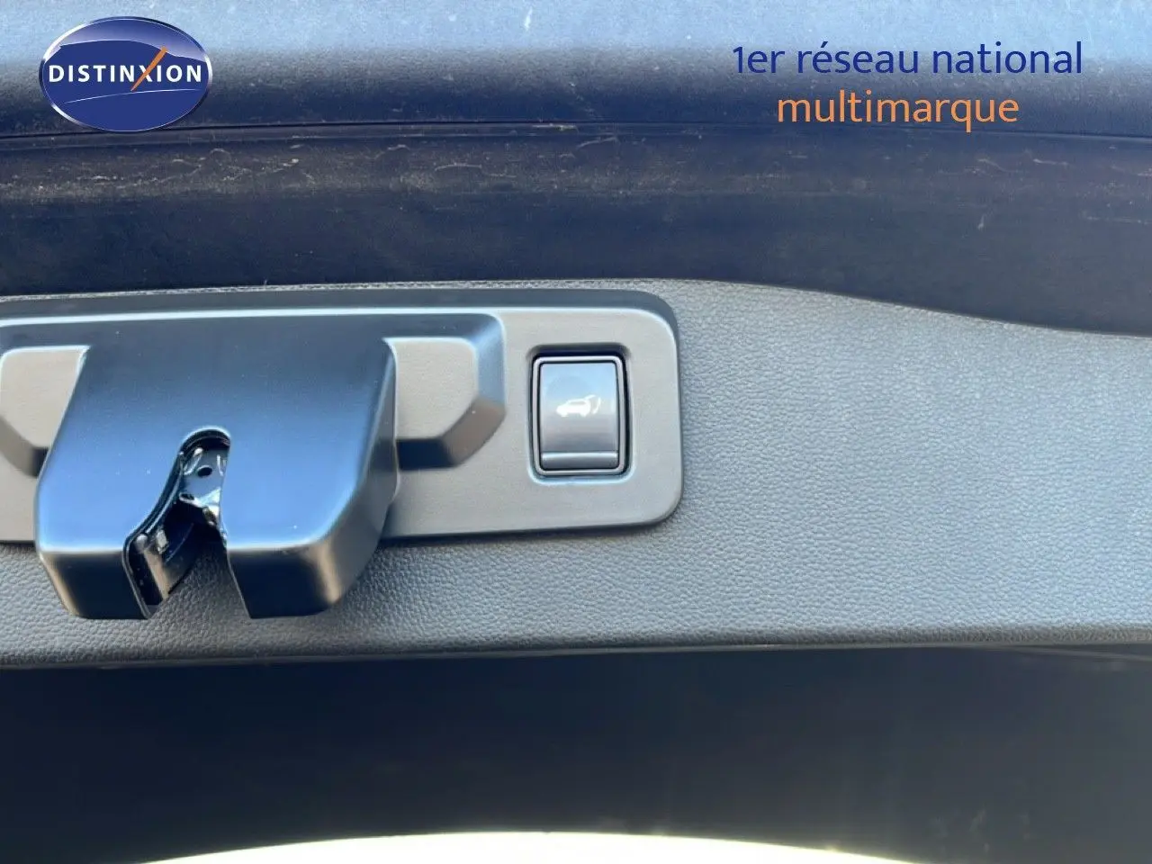 Gros plan sur la serrure et le bouton d'ouverture du coffre du Renault Austral noir étoile métal.