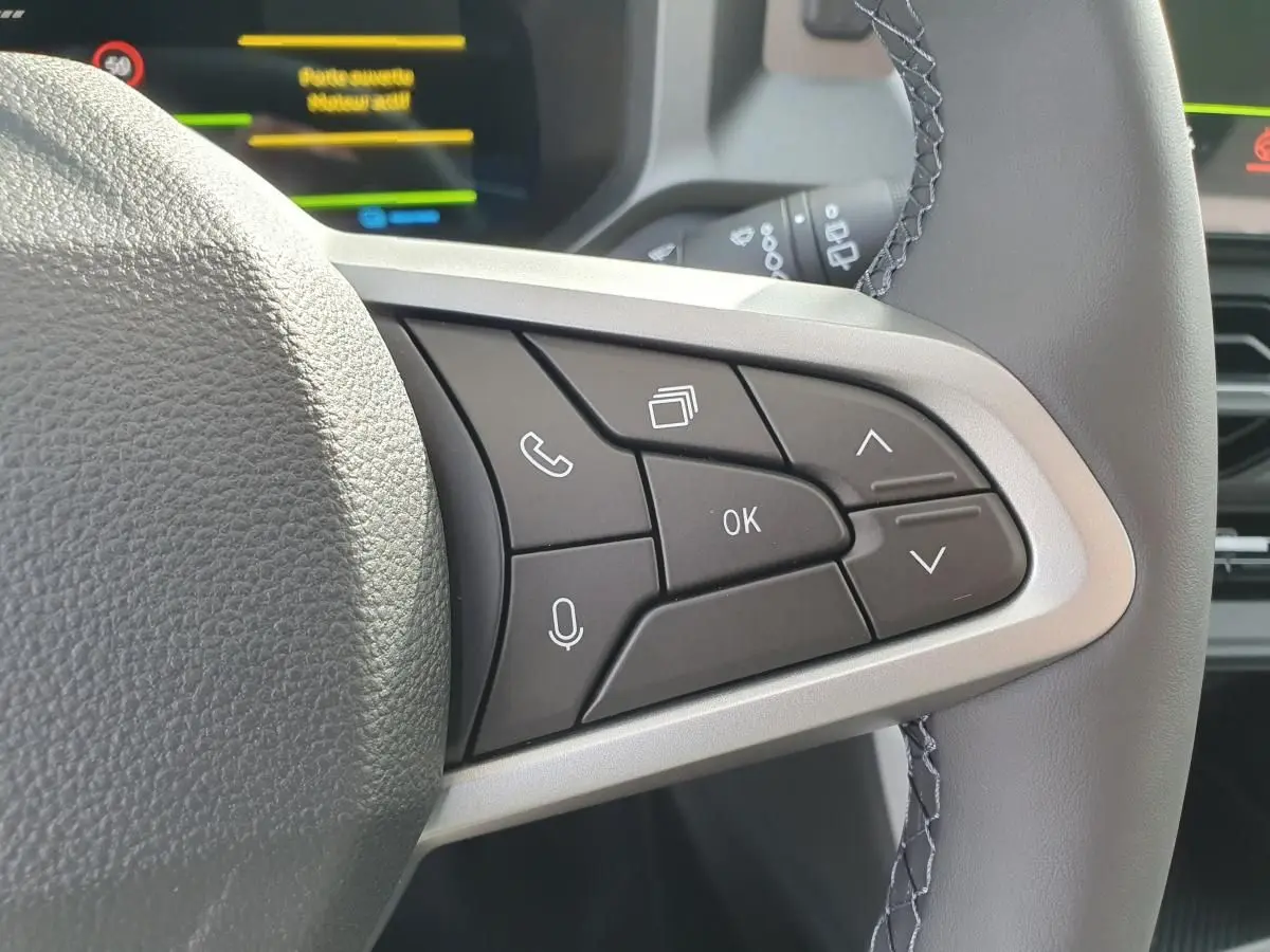 Gros plan sur les commandes multifonctions à droite du volant du Dacia Bigster, intérieur gris clair.