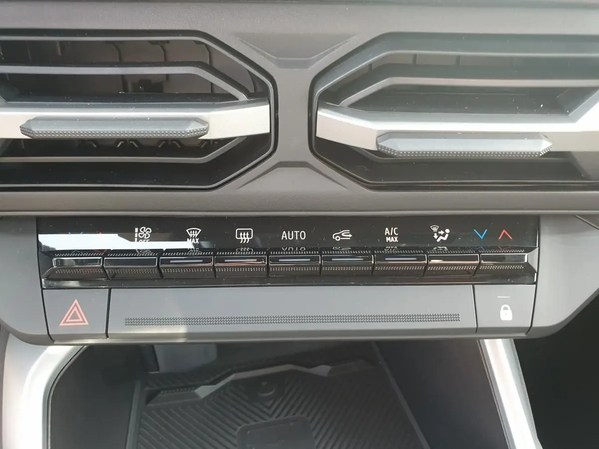 Vue rapprochée du tableau de bord du Dacia Bigster 2026, montrant les commandes de climatisation et ventilation.