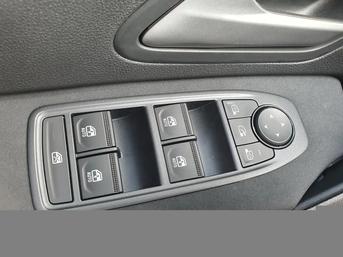 Gros plan sur les commandes des vitres électriques et rétroviseurs du côté conducteur dans un DACIA BIGSTER 2026.