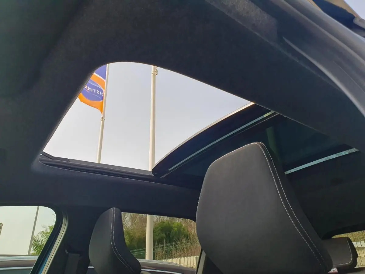 Vue intérieure du toit panoramique ouvert du Dacia Bigster 2026, avec appuie-tête avant en tissu noir.