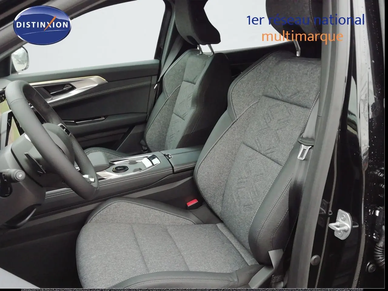 Vue intérieure côté conducteur du Renault Austral noir étoile métal, sièges tissu gris avec surpiqûres et volant multifonction.