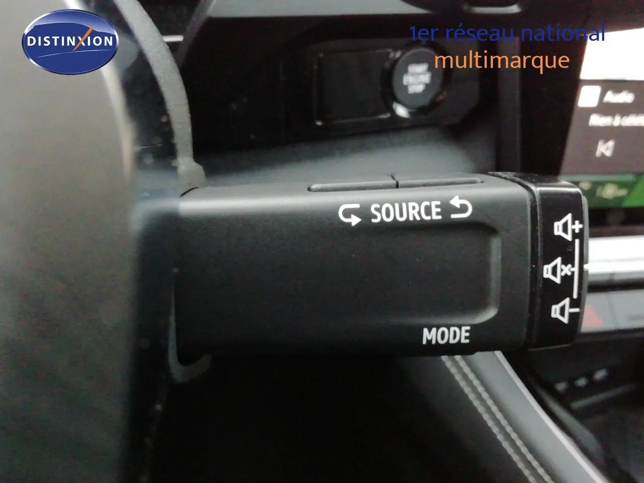 Gros plan sur la commande au volant du Renault Austral noir étoile métal, montrant les boutons source et mode.