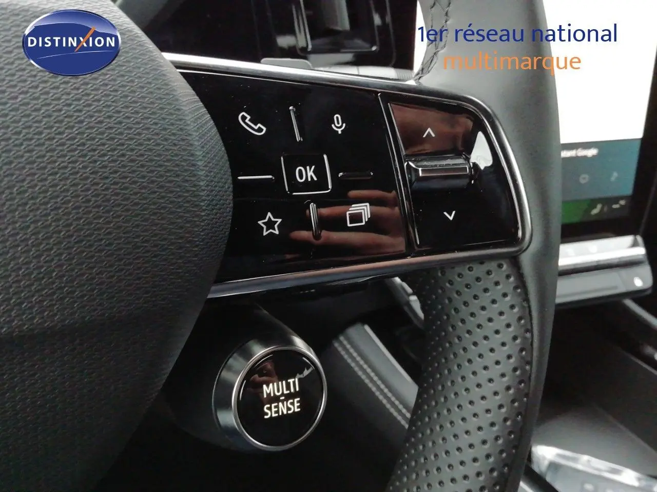 Gros plan sur le volant noir perforé du Renault Austral 2026, avec commandes intégrées et bouton Multi Sense.