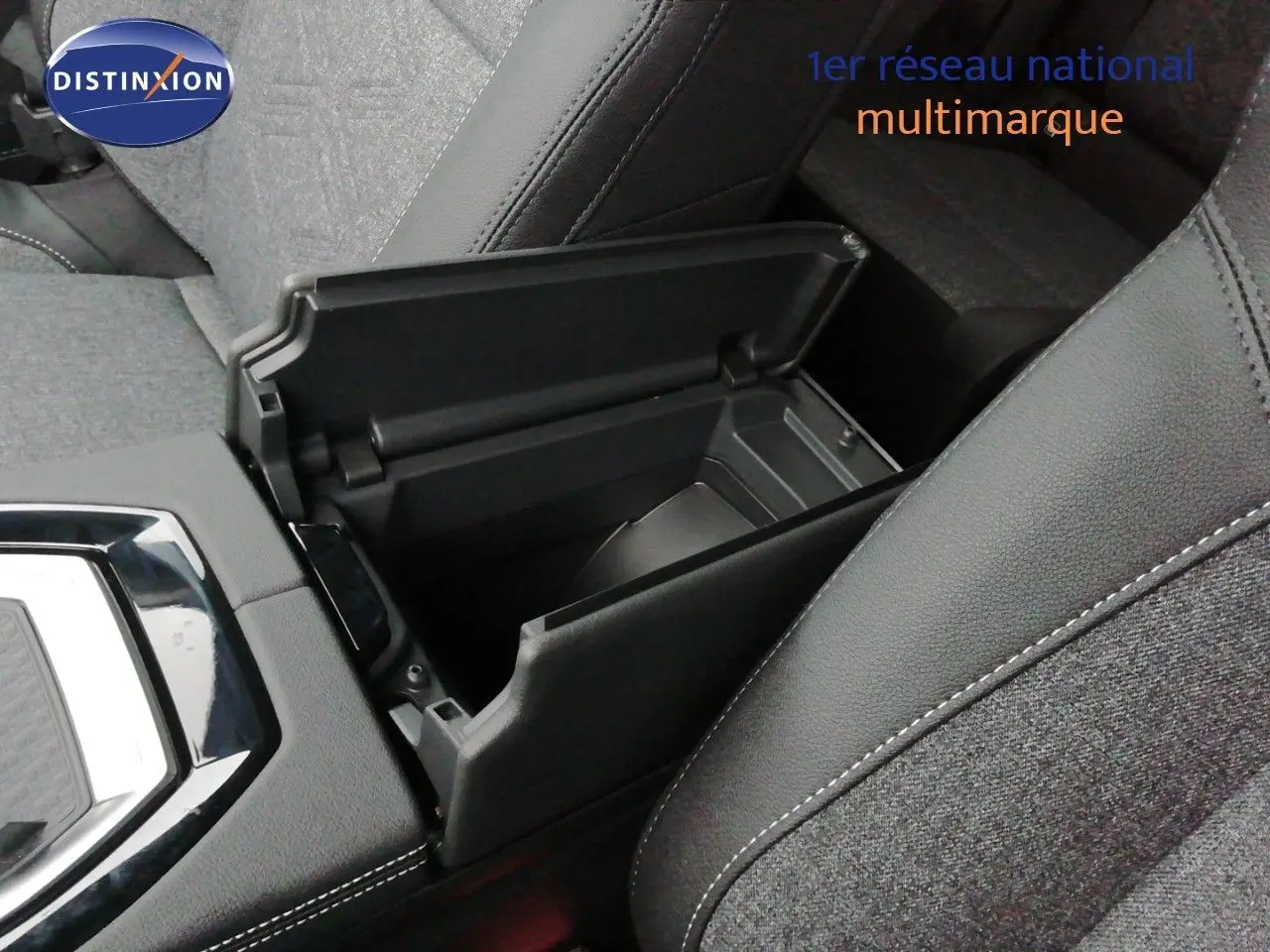 Détail de l'accoudoir central ouvert montrant le rangement intérieur du Renault Austral noir étoile métal.