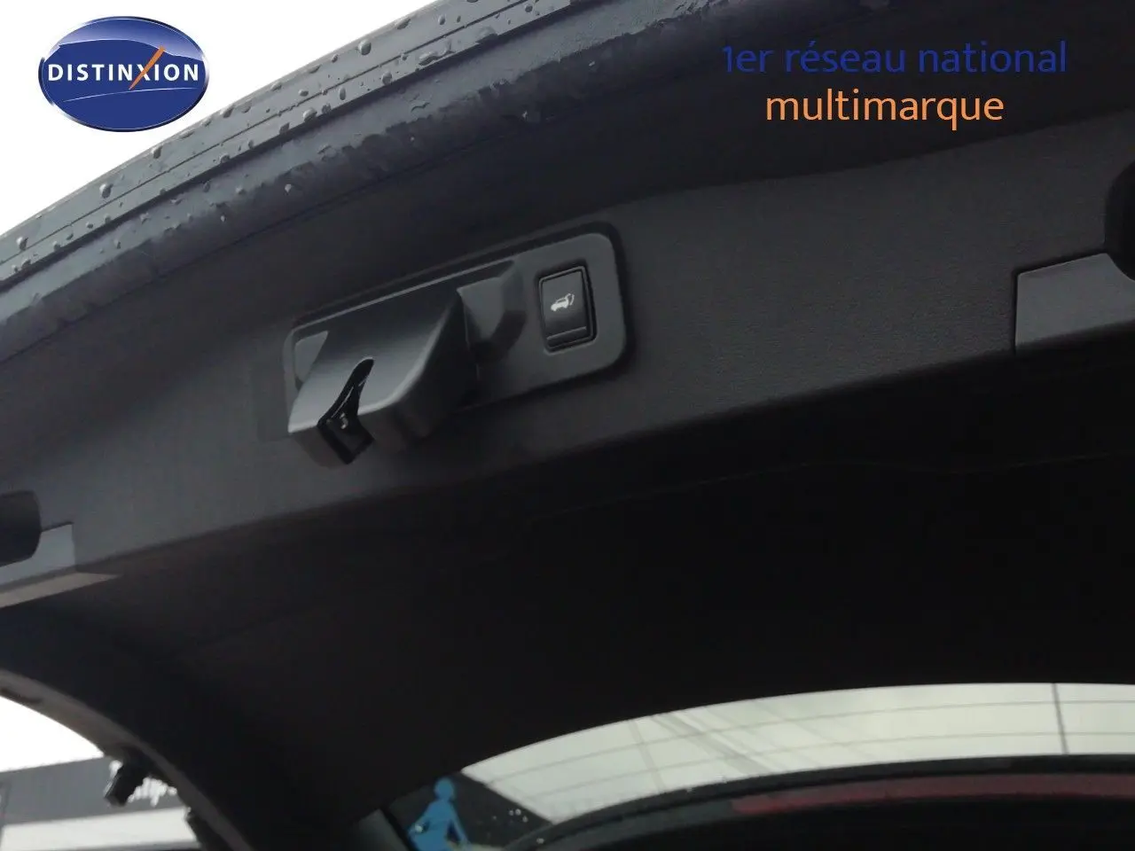 Détail du hayon ouvert du Renault Austral noir étoile métal montrant la commande d'ouverture électrique et le bouton de fermeture.