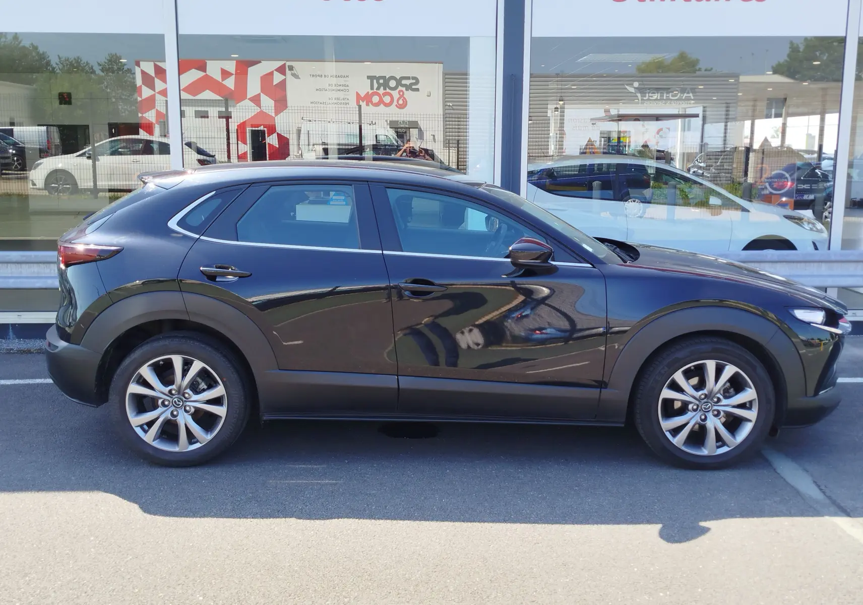 Vue latérale gauche d'un Mazda CX-30 noir 2020, SUV compact avec jantes alliage et lignes fluides modernes.