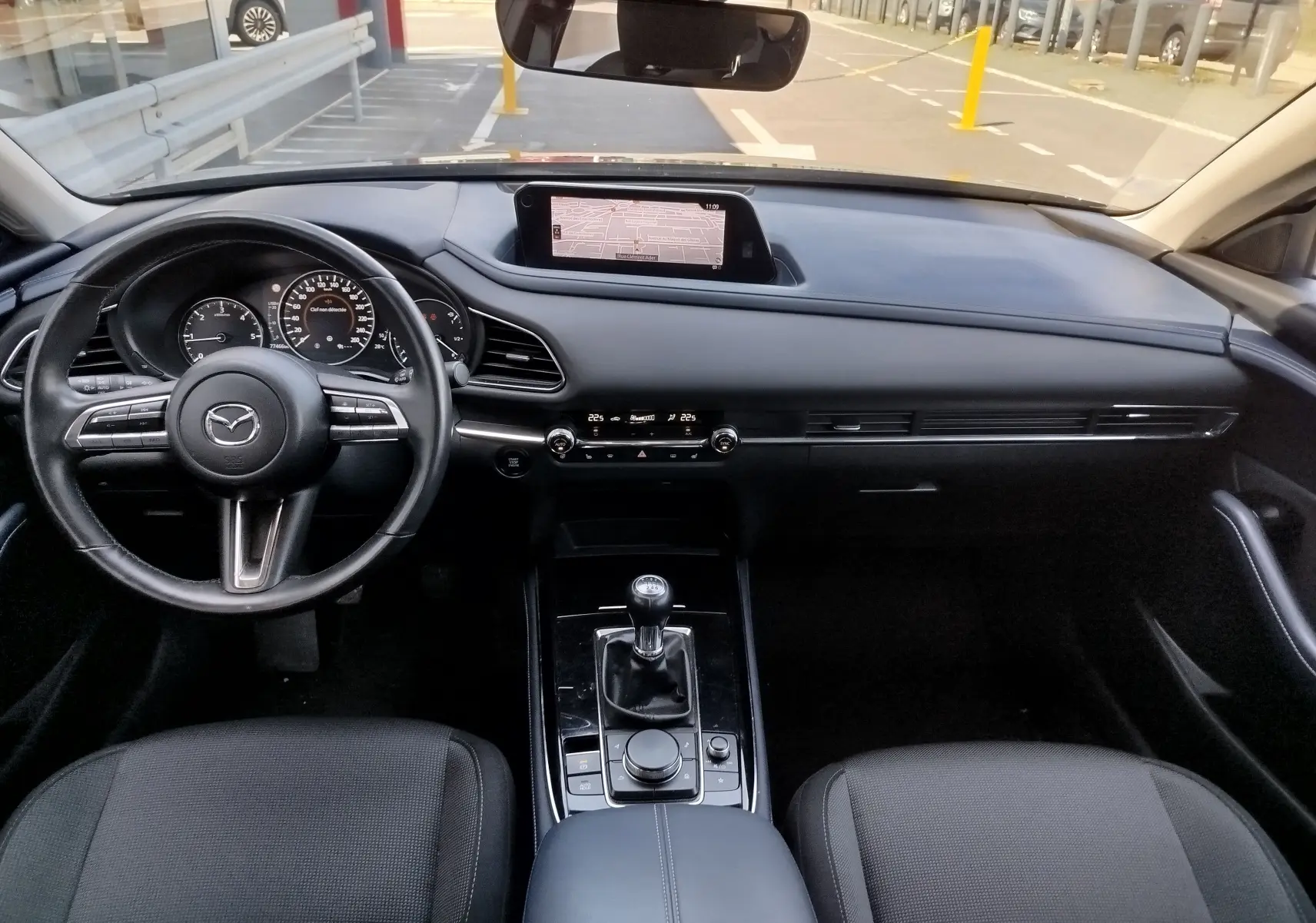 Vue intérieure avant du Mazda CX-30 2020 diesel noir, avec tableau de bord moderne et boîte manuelle au centre.