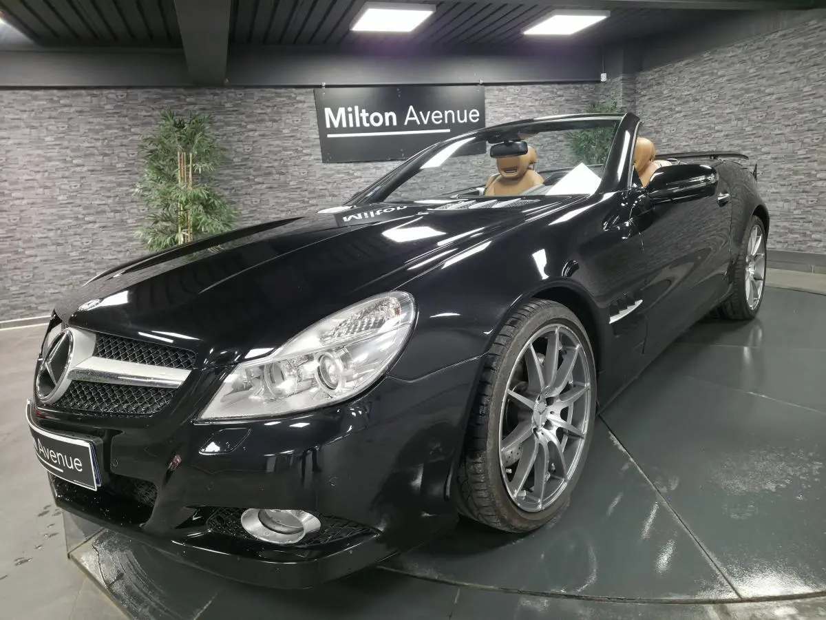 Mercedes SL 500 cabriolet noir vu en 3/4 avant droit avec jantes alliage 19 pouces et intérieur cuir beige.