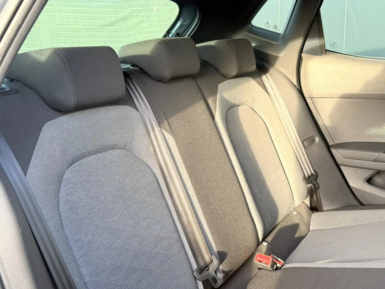 Vue intérieure sur la banquette arrière grise de la SEAT Ibiza 2025, montrant les appuie-têtes et ceintures de sécurité.
