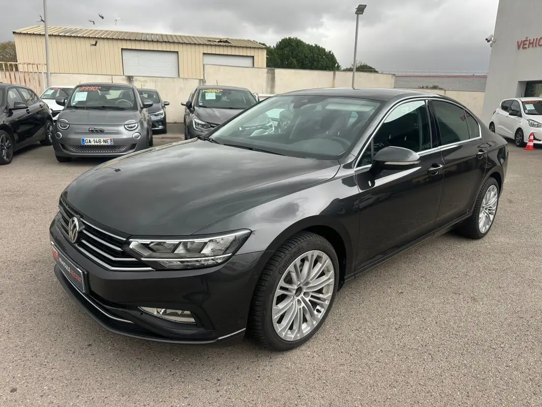 Volkswagen Passat Business gris foncé vue 3/4 avant droit avec jantes alliage 17 pouces sur parking.