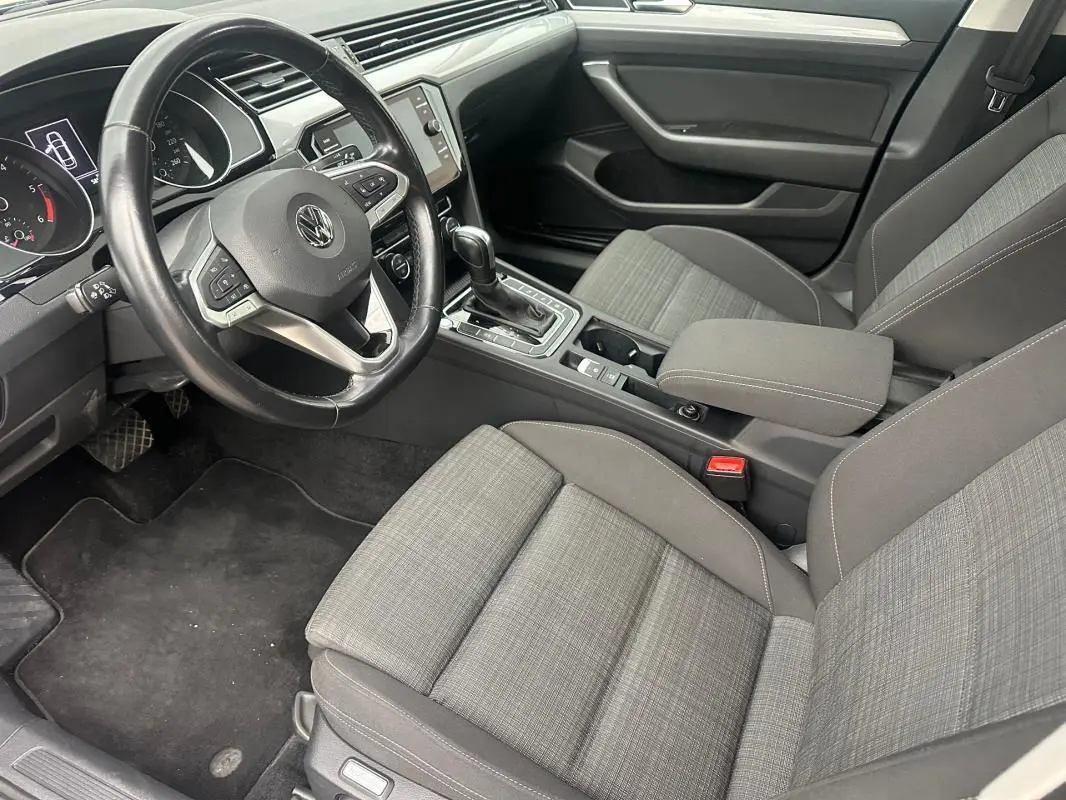 Intérieur gris clair de la Volkswagen Passat Business 2021, vue côté conducteur sur volant cuir et console centrale avec boîte auto.