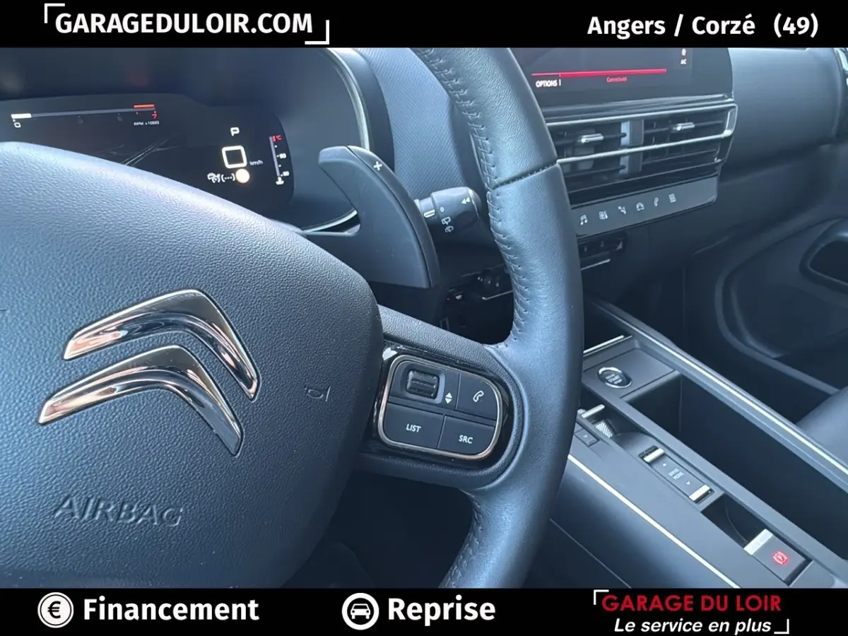 Vue rapprochée du volant cuir noir et tableau de bord central du Citroën C5 Aircross 2025 en intérieur.