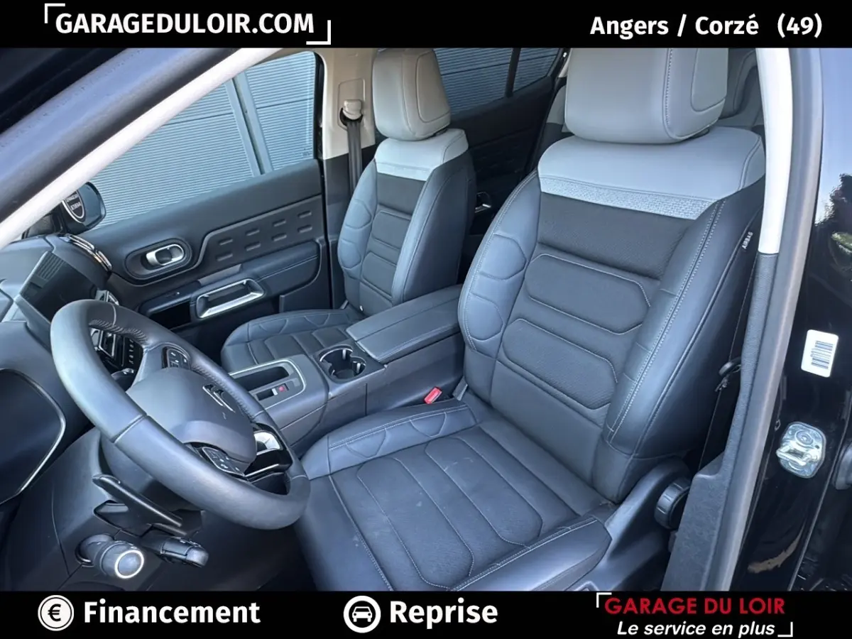 Vue intérieure côté conducteur du Citroën C5 Aircross noir 2025, sièges cuir bicolores et volant multifonctions.