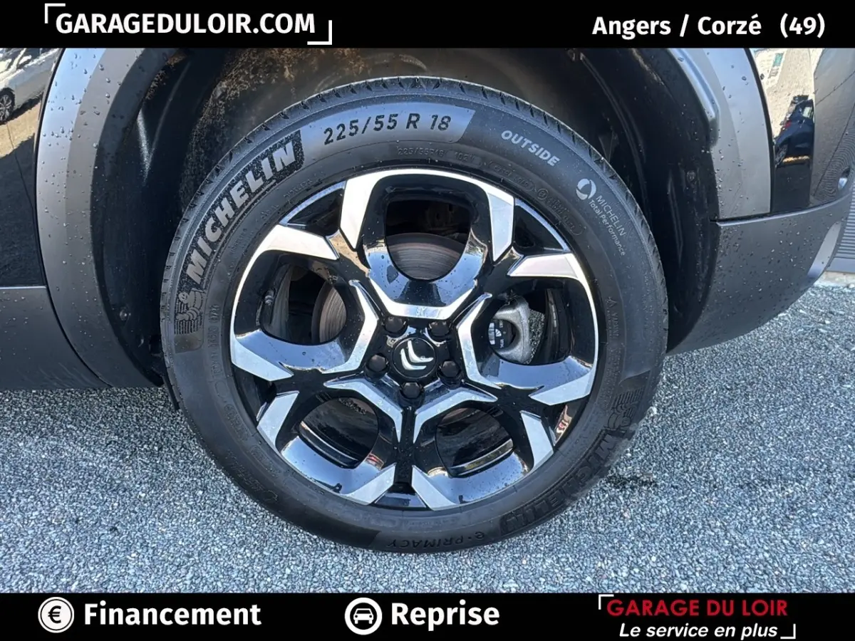 Gros plan sur la roue arrière droite noire d'un Citroën C5 Aircross 2025 avec jante alliage bicolore et pneu Michelin.