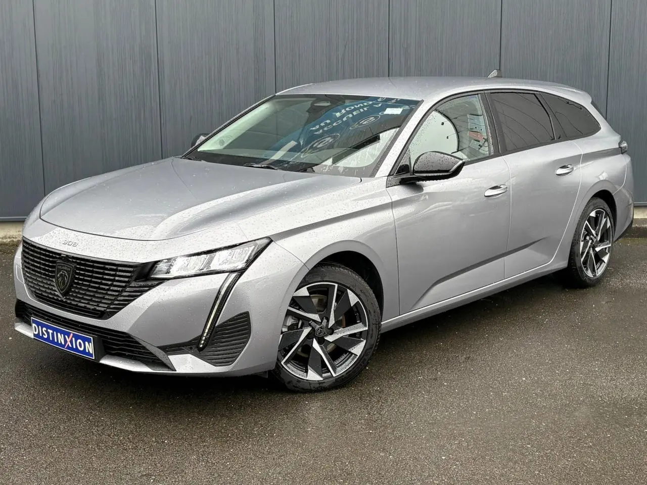 Peugeot 308 SW Hybrid gris Artense vue 3/4 avant droit avec jantes alliage et feux LED diurnes.