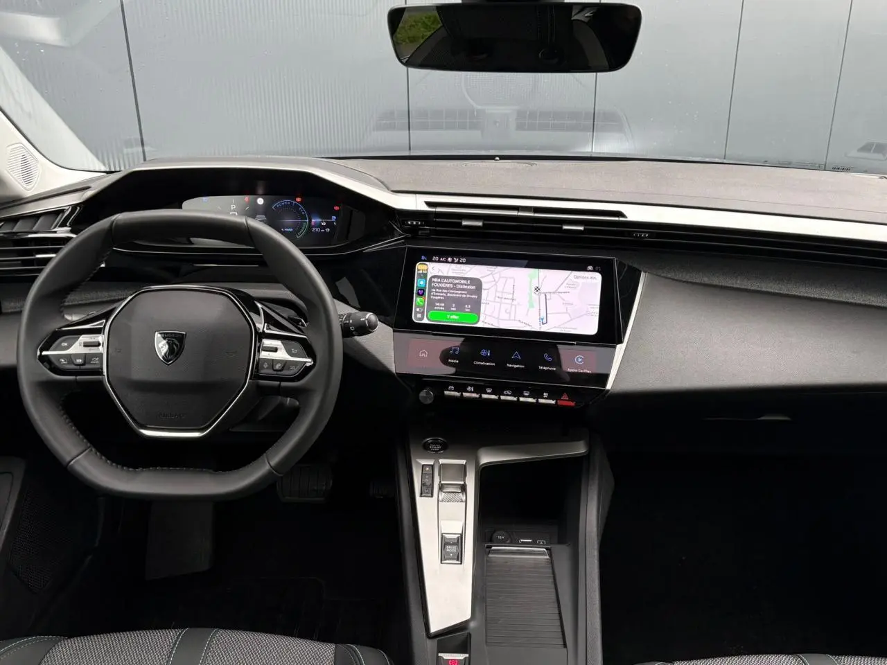 Vue intérieure avant du Peugeot 308 SW Hybrid 145 gris Artense, avec tableau de bord numérique et écran tactile central.