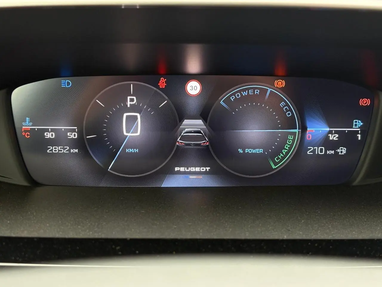 Tableau de bord numérique de la Peugeot 308 SW Hybrid 2025 affichant vitesse, autonomie et indicateurs d'énergie.