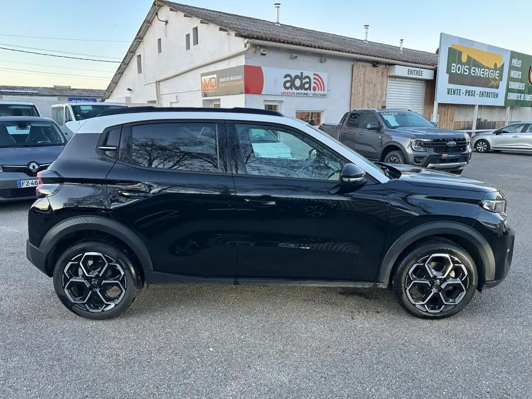 Vue de profil côté gauche d'une Citroën C3 noire 2025 avec jantes alliage 17 pouces et barres de toit visibles.