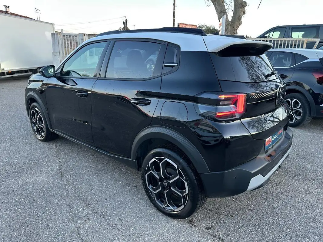 Vue 3/4 arrière droite d'une Citroën C3 noire 2025 avec jantes alliage 17 pouces et toit contrasté blanc.