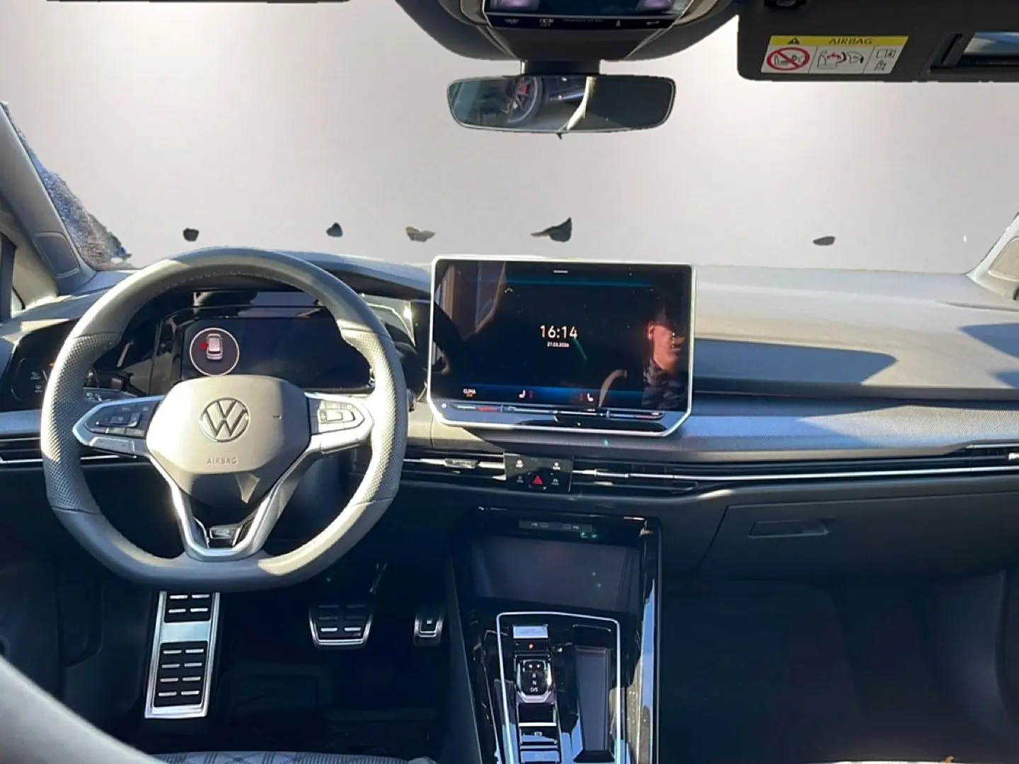Vue intérieure avant de la Volkswagen Golf 1.5 ETSI Evo2 noire, avec volant multifonction et écran tactile central.