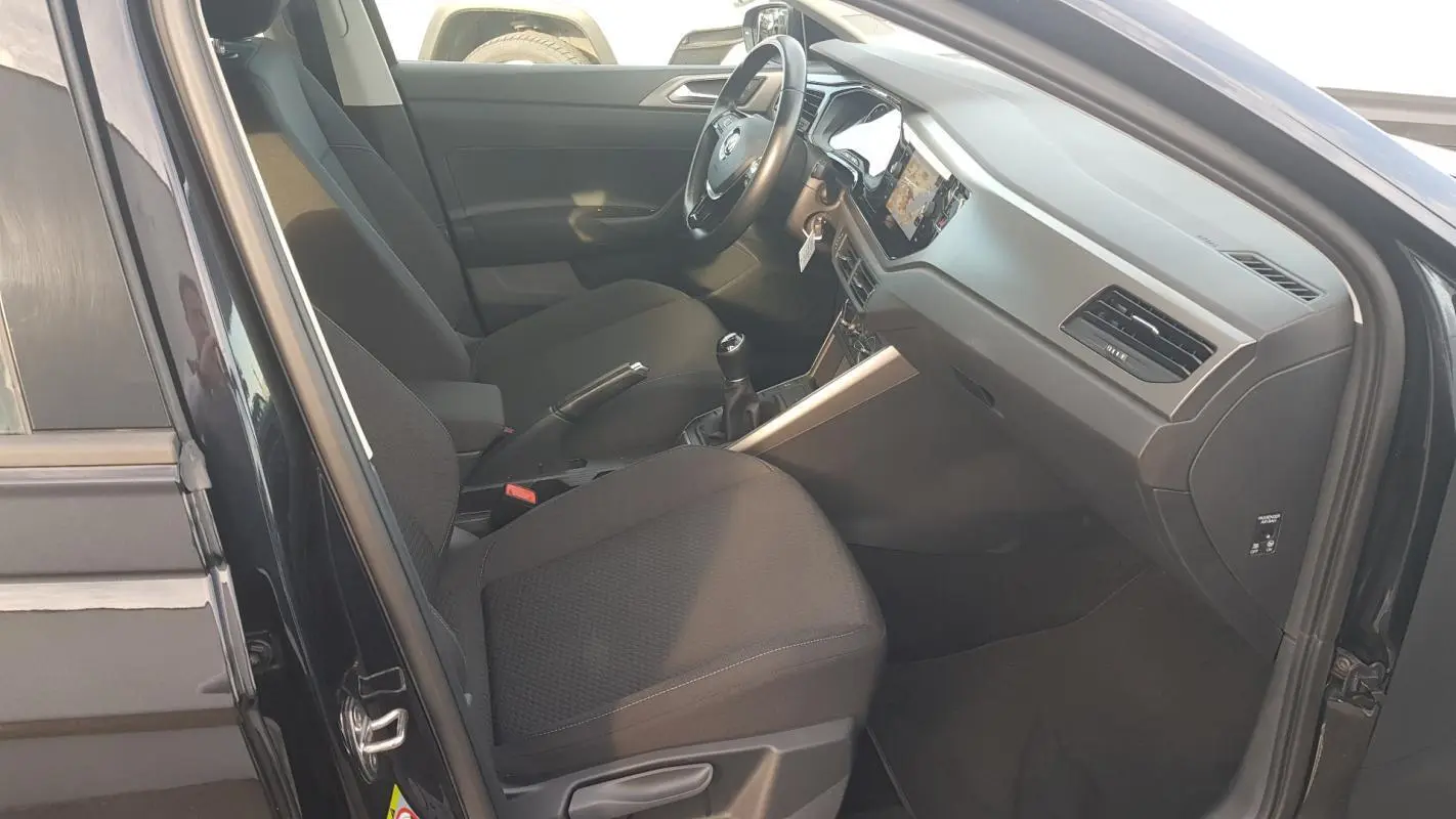 Intérieur noir de la Volkswagen Polo 2018, vue côté conducteur avec volant multifonctions et boîte manuelle.