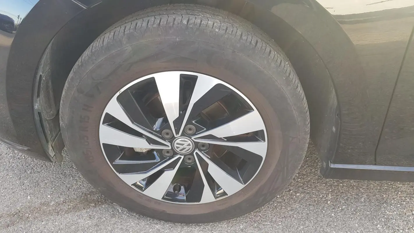 Gros plan sur la jante alliage bicolore noire et argentée d'une Volkswagen Polo noire, côté avant droit.