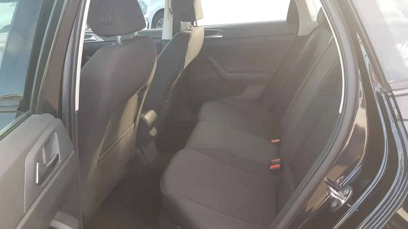 Vue intérieure arrière côté droit de la Volkswagen Polo noire 2018 montrant les sièges arrière en tissu et la portière ouverte.