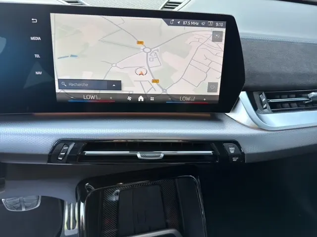 Vue intérieure du tableau de bord BMW X2 sDrive20d M Sport 2025 avec écran tactile de navigation et commandes climatisation.