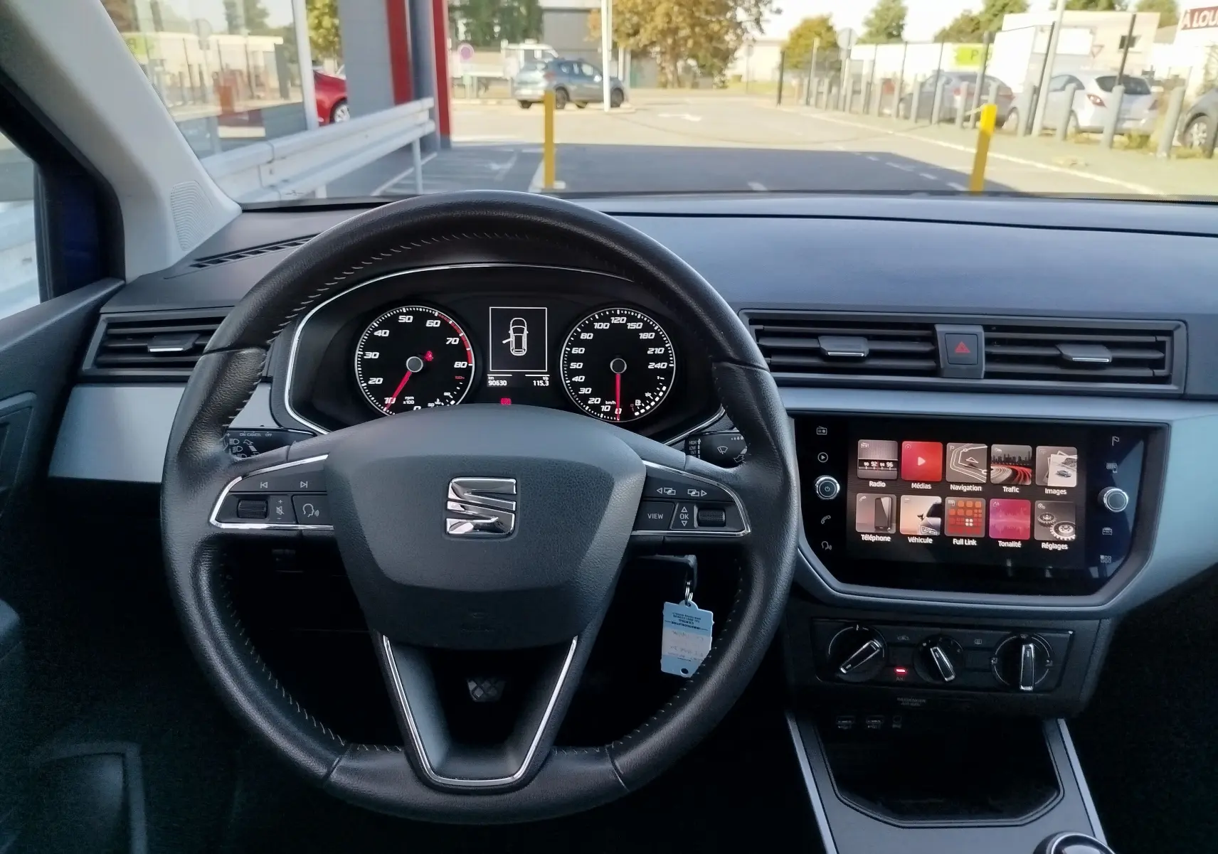 Vue intérieure centrée sur le volant et le tableau de bord d'une SEAT Arona 2019 avec écran tactile et commandes au volant.