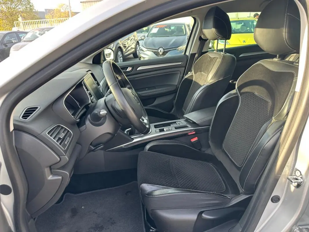 Intérieur côté conducteur de la Renault Mégane Break gris clair, sièges cuir et alcantara, tableau de bord moderne.
